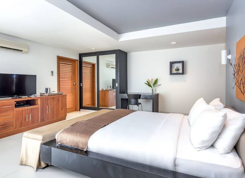 Villa Hening Jimbaran guest room with king bed, TV console, desk, and mirrored wardrobe in South Kuta