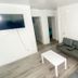 Uptown Inn & Suites in St. Petersburg living area with sofa, armchair, coffee table and wall-mounted TV