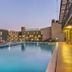 Kilimo Grand Resort Nairobi pool at dusk with lounge chairs and hotel buildings