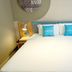 Home Inn Neo Wuxi Xihu East Road Dongting guest room with large bed, bedside lamps, and teal pillows