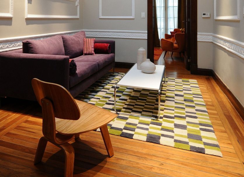Casa Umare Buenos Aires lounge with stained-glass skylight, purple sofa, wood chair and patterned rug