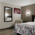 Red Roof Inn Hartford - New Britain guest room with king bed, wall mirror, and floor lamp