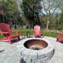 White Mountain Motel And Cottages in Lincoln: patio with fire pit, pink Adirondack chairs and trees