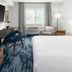 Fairfield Inn & Suites by Marriott San Francisco San Carlos guest room with king bed, desk, chair, and window seat