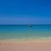 Relax Beach House in Ko Lanta with calm turquoise sea, sandy beach, and a small boat offshore