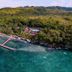 Aerial view of Magic Oceans Dive Resort in Anda with tropical coastline, pier, and ocean lagoon
