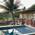 Pousada Recanto in Fernando de Noronha with a pool deck, palm trees, and room balconies