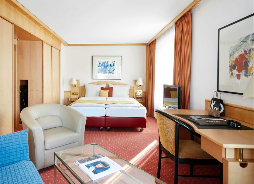 Living Hotel Großer Kurfürst in Berlin guest room with sofa, desk, twin beds, and red carpet