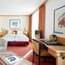 Living Hotel Großer Kurfürst in Berlin guest room with sofa, desk, twin beds, and red carpet