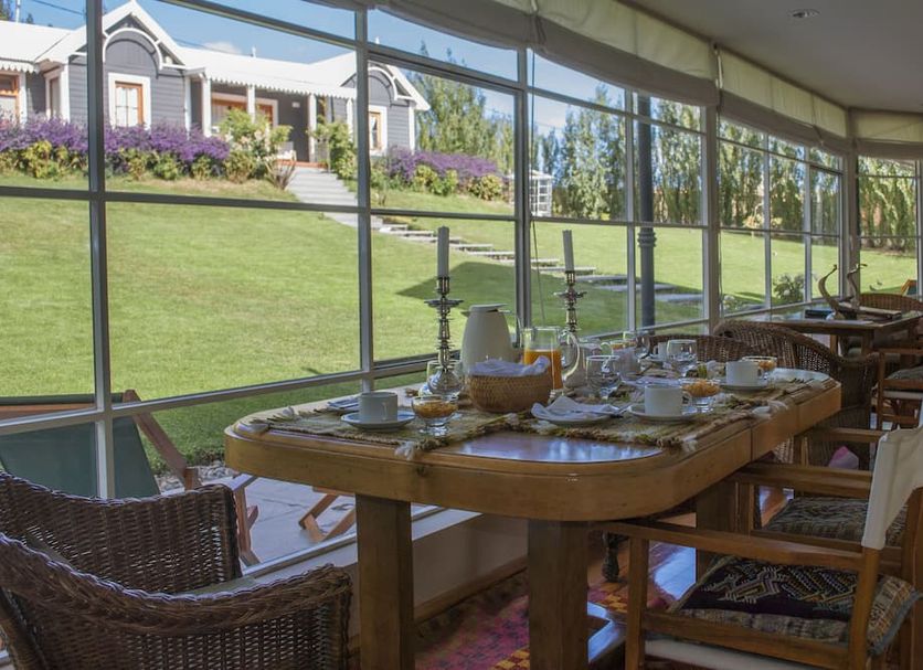 Los Ponchos Hotel in El Calafate dining room with large windows overlooking a green hillside