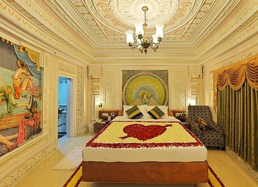 Hotel Ambica Empire Chennai ornate suite with king bed, chandelier, mural wall art and draped windows