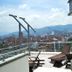 Inntu Hotel Medellín rooftop terrace with city and mountain views, lounge chairs, and glass railing