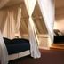 De Utrechtsche Dom, Gouda: canopy bed with sheer curtains in a cozy guest room