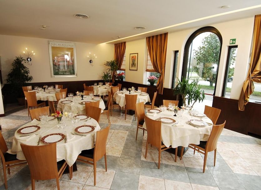 Park Hotel Ripaverde dining room in Borgo San Lorenzo with set tables and arched window