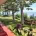 Auberge La Coudriere in L'Isle-aux-Coudres with lakeside terrace, red chairs, picnic table and trees
