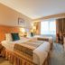 Crowne Plaza Vilnius in Vilnius guest room with two beds, desk, TV and window with curtains