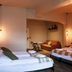 Kex Reykjavík in Reykjavik: hotel room with multiple beds, seating area, and warm pendant lighting