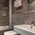Hôtel Edmond Rostand Marseille bathroom with bathtub, sink, toilet and gray tile walls