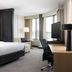 Residence Inn by Marriott Grand Rapids Downtown guest room with bed, desk, sofa, and city-view windows