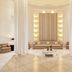 Juweira Boutique Hotel Salalah lobby seating area with white columns and warm wall lights