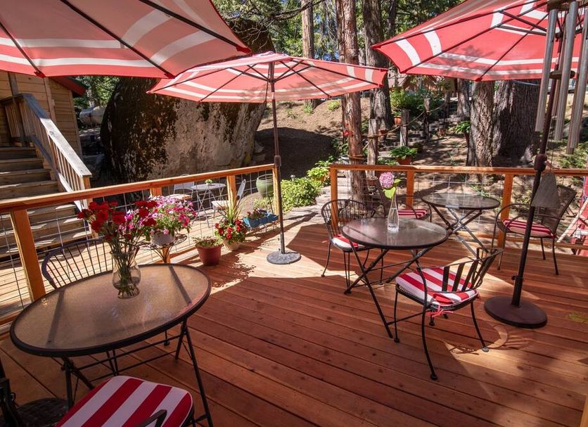 Elliott House Boutique Inn in Shaver Lake with a wooden deck, red umbrellas, and forest views