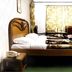Himgiri Resorts in Dharamshala guest room with carved wooden bed, floral curtains, and TV