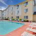 Super 8 by Wyndham Clearwater/St. Petersburg Airport pool with lounge chairs and palm trees in Clearwater