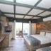 The Sarigerme Inn room in Sarigerme with two beds, wood-accent walls, and a balcony door