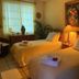 The Mexican Inn in Cabo San Lucas guest room with two twin beds, lamp, painting, and window light