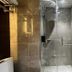 EGI Resort and Hotel Lapu-Lapu City bathroom with glass-enclosed shower and marble-style tile walls