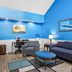 Baymont by Wyndham Forest City lobby with blue walls, seating area, lamps, and a desk