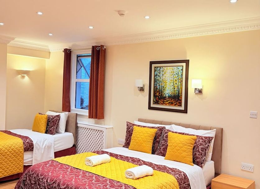 Europa House Hotel London twin room with two beds and warm wall lighting