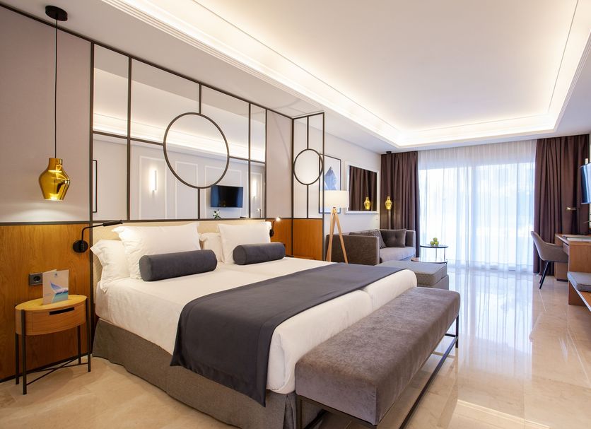 Grupotel Playa de Palma Suites & Spa, S'Arenal: modern suite with king bed, bench, desk and balcony doors