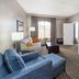 Wingate by Wyndham Sylvania/Toledo guest room with sofa, TV, and window seating area