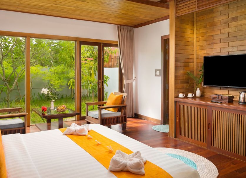 Khmer House Resort Siem Reap guest room with bed, TV, wood accents and garden view