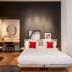 Le Cinq Codet Paris guest room with queen bed, freestanding bathtub, and desk nook
