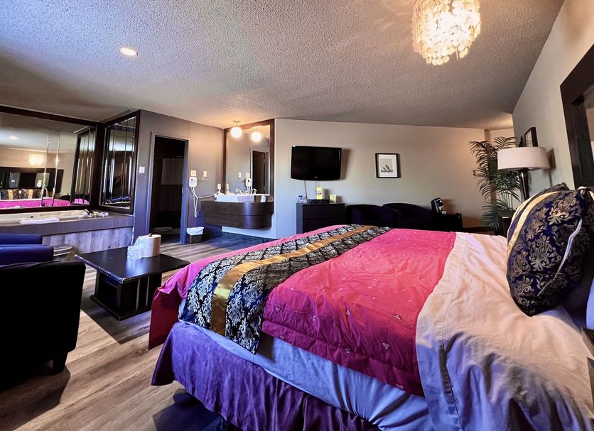 Hotel L'Express Longueuil guest room with king bed, wall-mounted TV and modern bathroom
