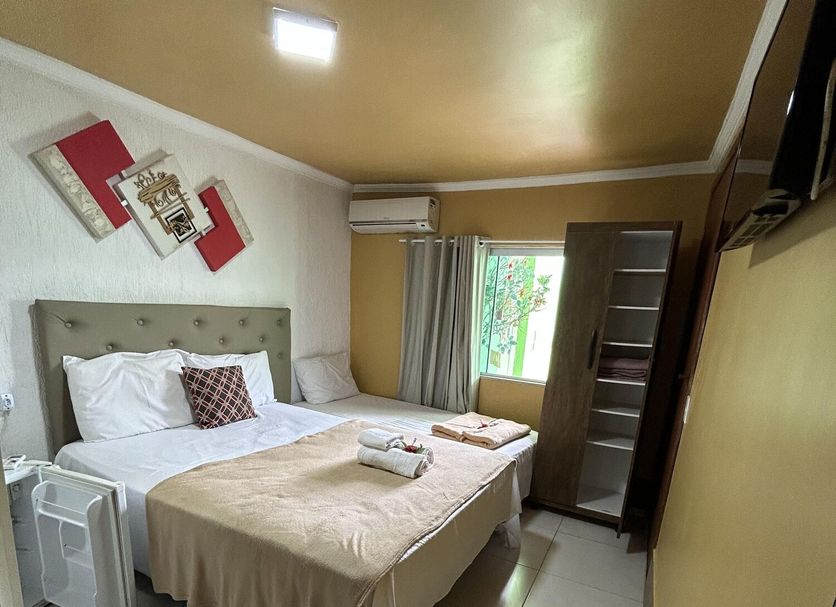 Pousada Caminho do Pontal guest room in Arraial do Cabo with bed, window, TV and tiled floor