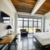 Wythe Hotel in Brooklyn room with king bed, city skyline view, and wood-beamed ceiling