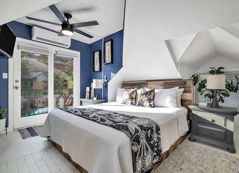 Red Rock Inn Cottages Springdale guest room with king bed, balcony doors, ceiling fan and vaulted nook