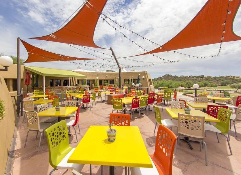 Gold Canyon Golf Resort patio dining area with colorful tables, shade sails, and desert views in Gold Canyon