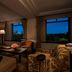 The Ritz-Carlton New York Central Park suite with city skyline views through large windows at night