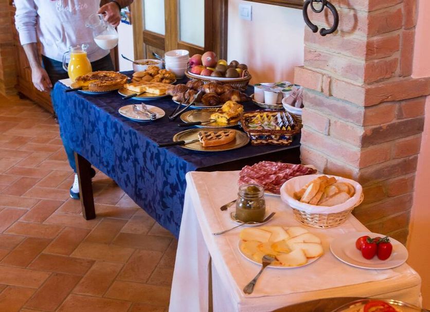 Breakfast buffet at Agriturismo Poggio Tobruk in Pienza with pastries, fruit, cheeses and cold cuts
