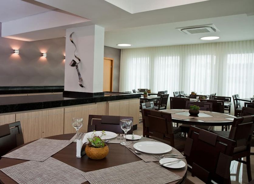 Bh Jaraguá Hotel in Belo Horizonte restaurant dining area with set tables and bright windows