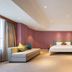 Wanhao International Hotel Benxi guest room with bed, sofa, and mauve paneled walls