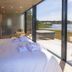 Käringsund Resort in Eckerö guest room with bed beside floor-to-ceiling windows and lake view