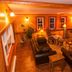 Gîte Au Coin De La Berge in Perce lounge with leather sofas, TV, fireplace and warm orange walls