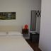 B&B La Casa Rossa in Paola bedroom with double bed, wall art, bedside tables and mirror