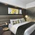 The Capital Menlyn Maine Pretoria guest room with king bed, abstract wall art and modern seating