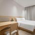 Hi Inn (Xuzhou Yunlong Wanda Plaza) guest room with bed, desk, wall-mounted TV and floor-to-ceiling curtains